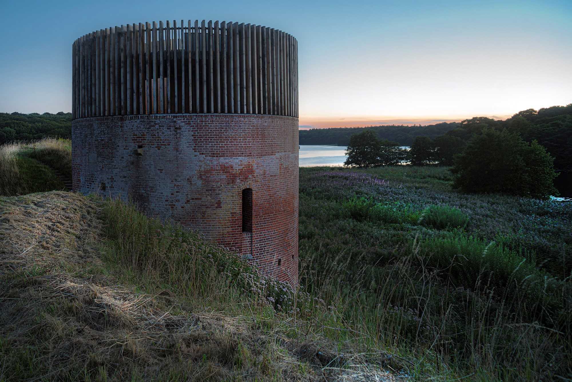 Solnedgangsbillede af Hald Slot med kig til Hald Sø