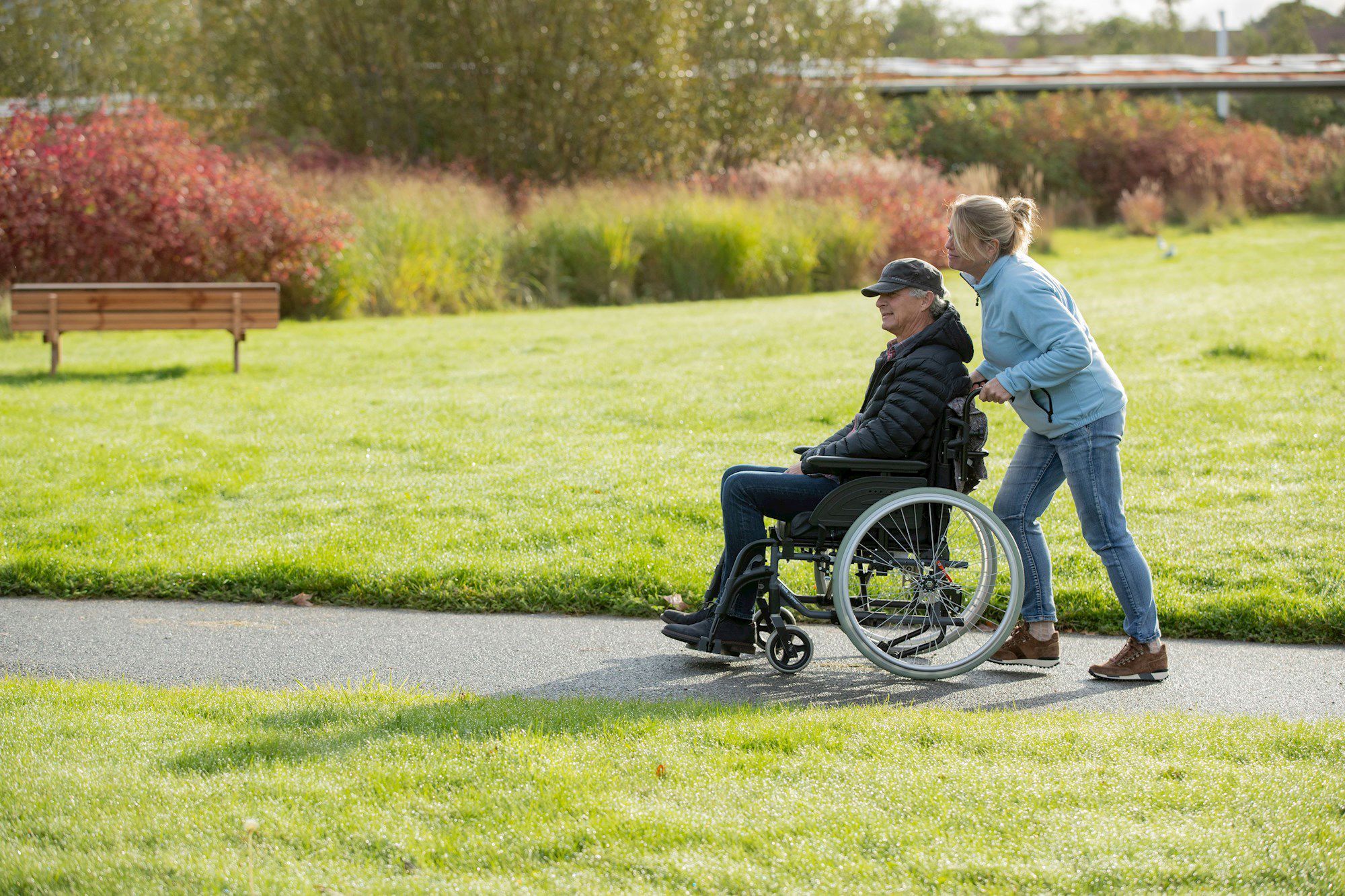 Medarbejder skubber mand i kørestol udenfor
