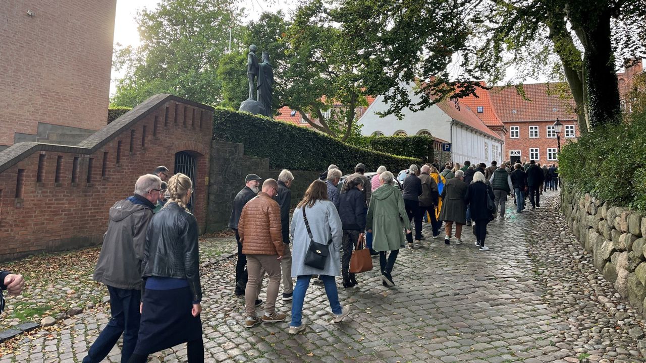 En gruppe voksne personer følger en guide på Grå Brødre Kirkestræde