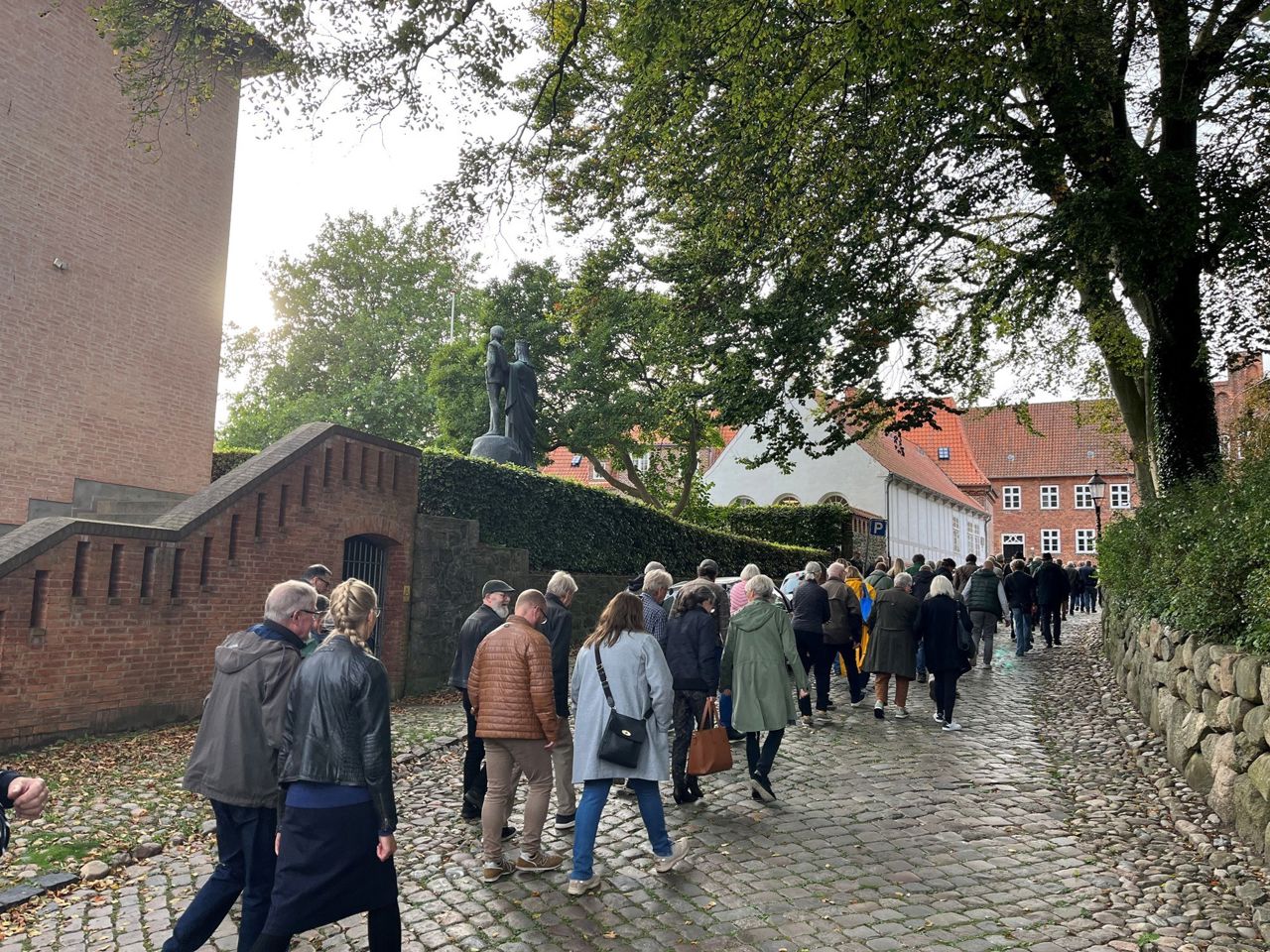 En gruppe voksne personer følger en guide på Grå Brødre Kirkestræde