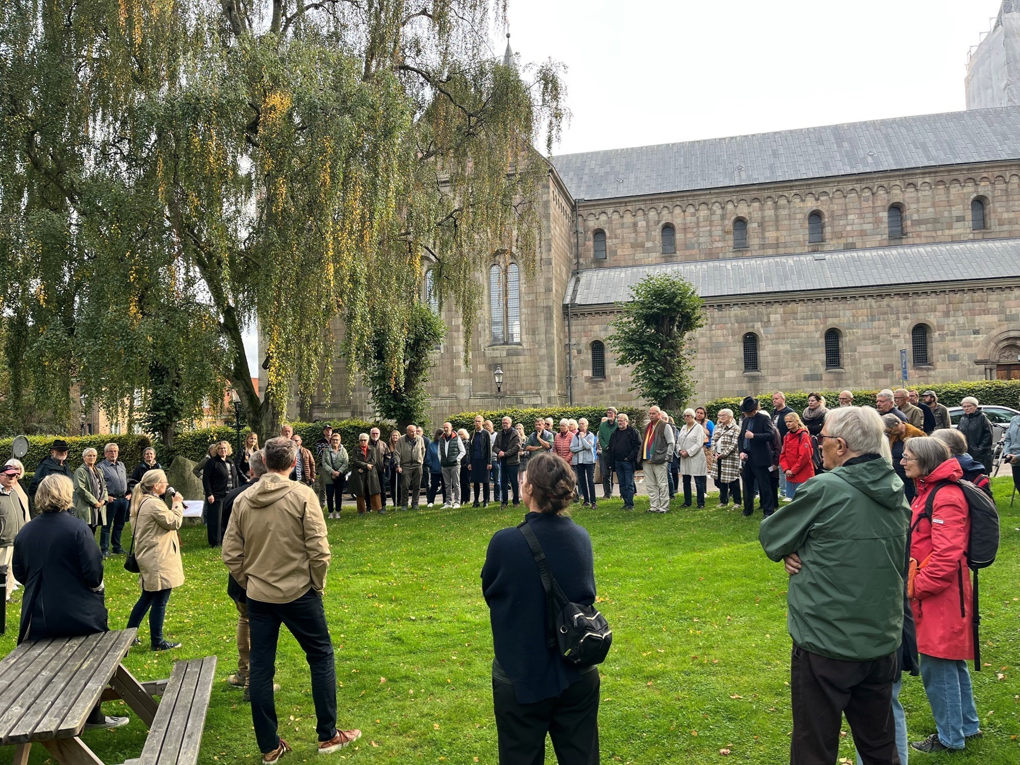 En gruppe voksne personer står ved Viborg Domkirke.