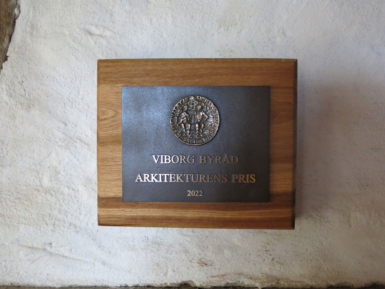 Nærbillede af plaketten, der blev givet for Arkitekturens Pris i 2022, hænger i Hald Laden