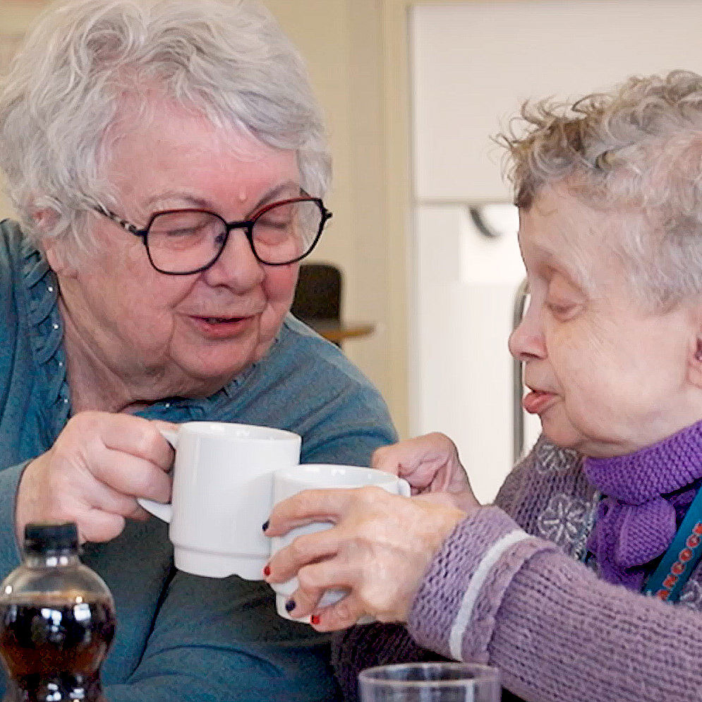 En frivillig drikker kaffe med en borger på socialområdet