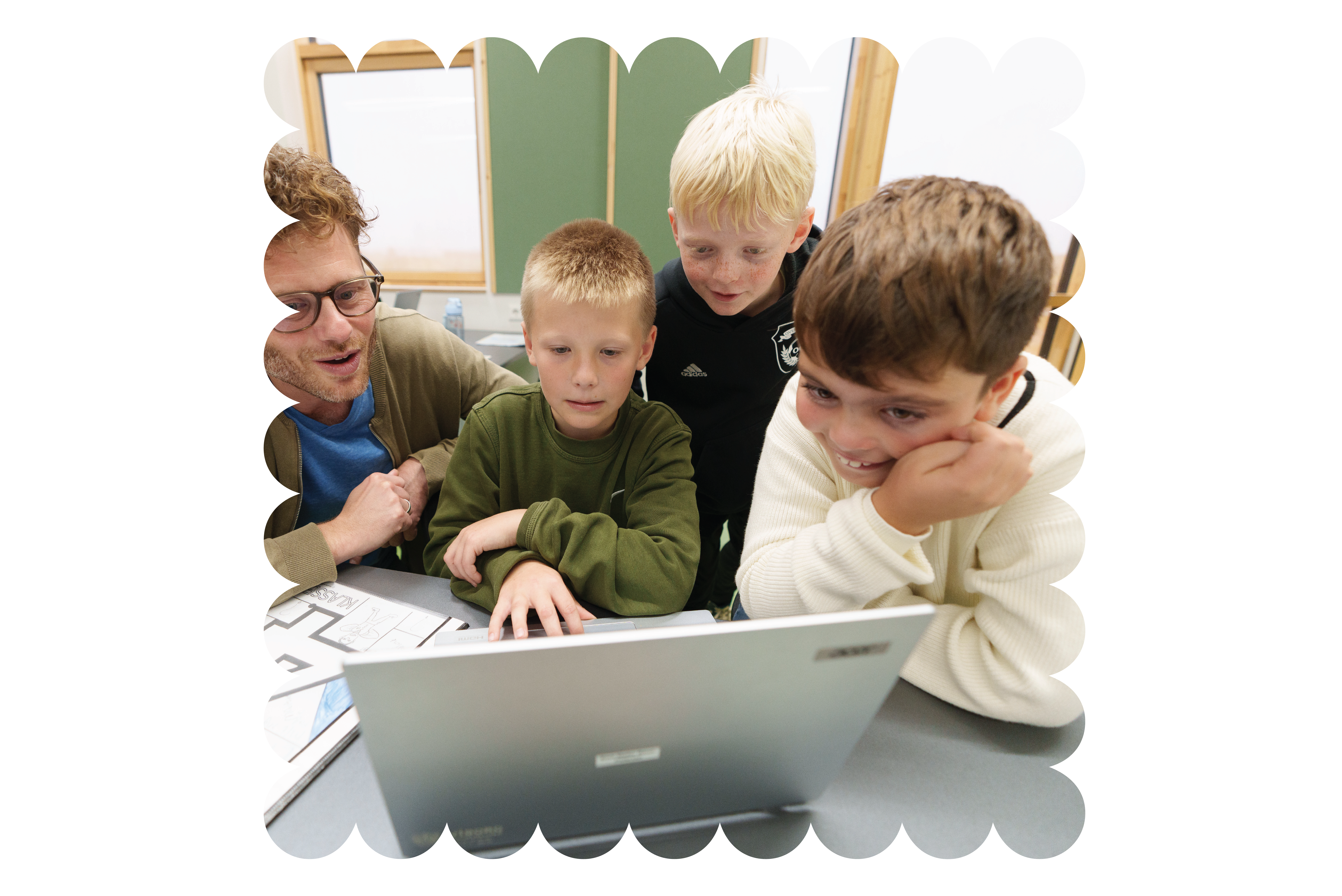 Børn i indskolingen kigger på pc sammen med voksen